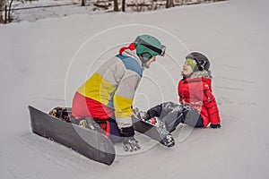 Snowboard instructor teaches a boy to snowboarding. Activities for children in winter. Children`s winter sport