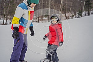 Snowboard instructor teaches a boy to snowboarding. Activities for children in winter. Children`s winter sport