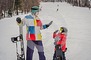 Snowboard instructor teaches a boy to snowboarding. Activities for children in winter. Children`s winter sport