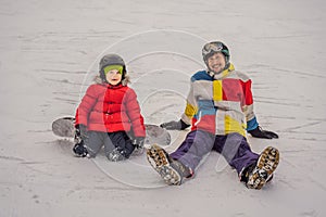 Snowboard instructor teaches a boy to snowboarding. Activities for children in winter. Children`s winter sport