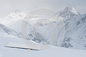 Snowboard at slope in the Alpine mountains