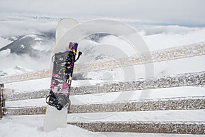 Snowboard stick in snow mountains on background