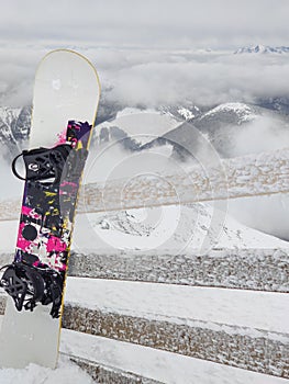 Snowboard stick in snow mountains on background