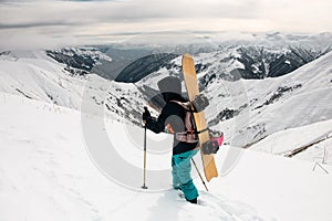 Snowboarder on the background of snow-capped mountains and cloudy sky.