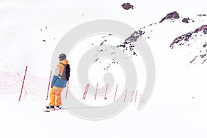 Snowboarder in a black helmet riding on a snowy track. Man learns to snowboarding rides over fresh snow on the slope in winter, ex