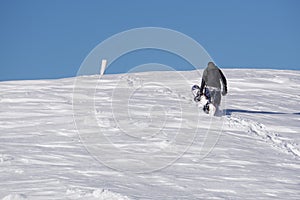 Snowboarder climbing a snowy mountain