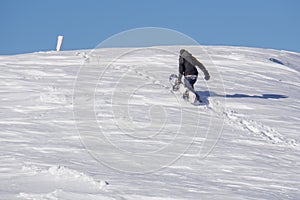 Snowboarder climbing a snowy mountain
