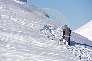 Snowboarder climbing a snowy mountain