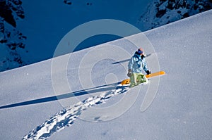 Snowboarder climbing to the peak