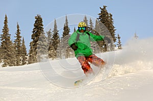 Snowboarder doing a toe side carve with deep blue sky in background