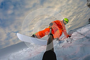 Snowboarder doing a trick and making a selfie