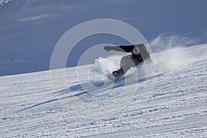 Snowboarder on the downhill in sunny day