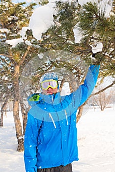 A snowboarder enjoying life, playing with snow, resting at a ski