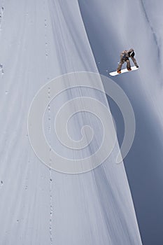 Snowboarder flying on the background of snowy slope. Extreme winter sports, snowboarding.