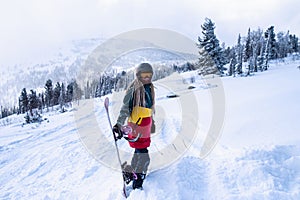 Snowboarder freerider woman on a snowy slope in mountains