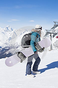 Snowboarder girl on the background of the mountains.