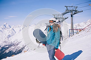 Snowboarder girl on the background of the mountains.