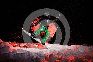 Snowboarder girl dressed in a green sportswear jumping on the mountain hill
