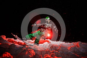 Snowboarder girl dressed in a green sportswear riding on the mountain hill