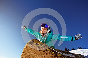 Snowboarder girl lies on the stone blue sky backdrop