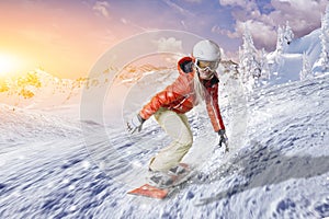 Snowboarder glides with high speed downhill through the powder snow