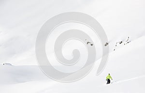 Snowboarder goes downhill in fresh powder snow in a winter mount