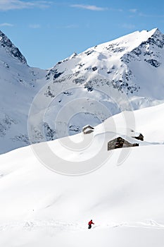 Snowboarder goes downhill over a snowy mountain landscape.
