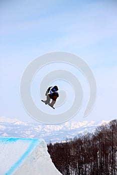 Snowboarder going off a big jump in hanazono park