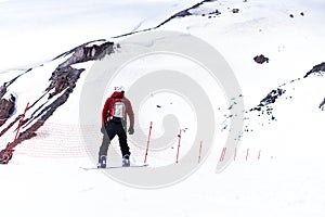 Snowboarder in a helmet riding on a snowy track. Snowboarder rides over fresh snow on the slope in winter, extreme sport