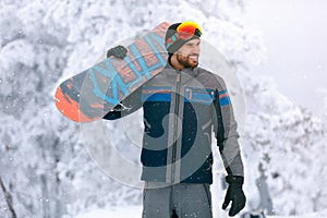 Snowboarder holding board on terrain