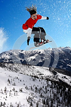 Snowboarder jumping against blue sky