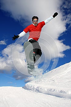 Snowboarder jumping against blue sky