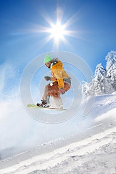 Snowboarder jumping against blue sky