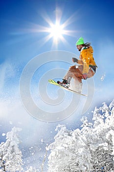 Snowboarder jumping against blue sky