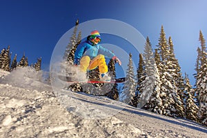 Snowboarder jumping against blue sky