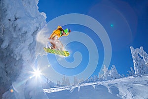 Snowboarder jumping against sunset