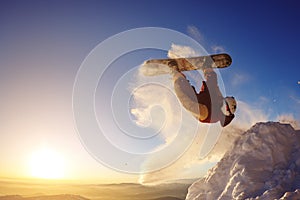 Snowboarder jumping against the sunset sky