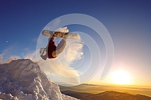 Snowboarder jumping against the sunset sky