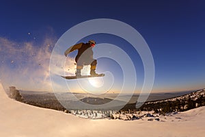 Snowboarder jumping against the sunset sky