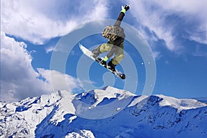 Snowboarder jumping through air with blue sky background