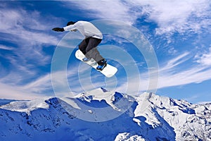 Snowboarder jumping through air with blue sky background