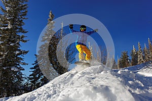 Snowboarder jumping through air with deep blue sky in background