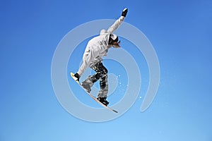 Snowboarder jumping through air with sky in background