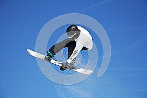 Snowboarder jumping through air with sky in background