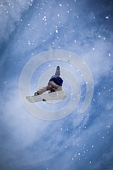 Snowboarder jumping with blue sky in background.