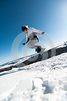 Snowboarder jumping on blue sky background
