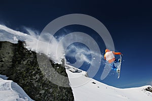 Snowboarder jumping from a cliff