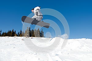 Snowboarder jumping from snow kicker