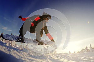 Snowboarder jumping from the springboard against the sky