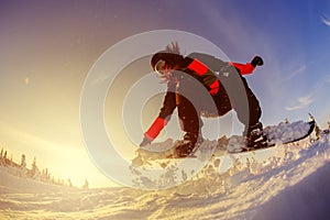 Snowboarder jumping from the springboard against the sky